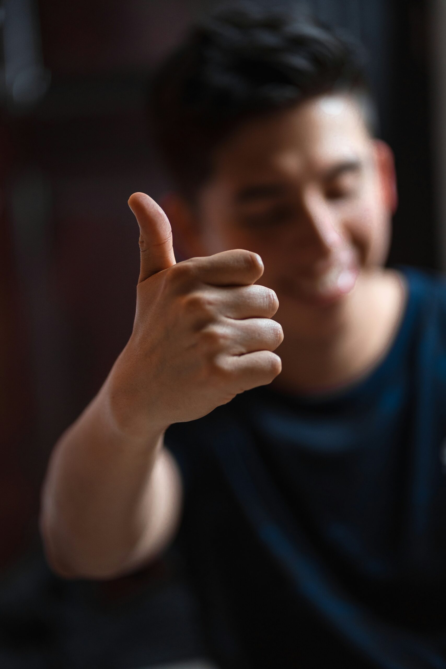 Iemand steekt zijn duim op en lacht. Foto geeft aan dat een review van een persoon zoals zij, bij je klanten meer vertrouwen opwekt dan een anonieme like op social media. Een motivering om reviews van klanten in te zetten in marketing