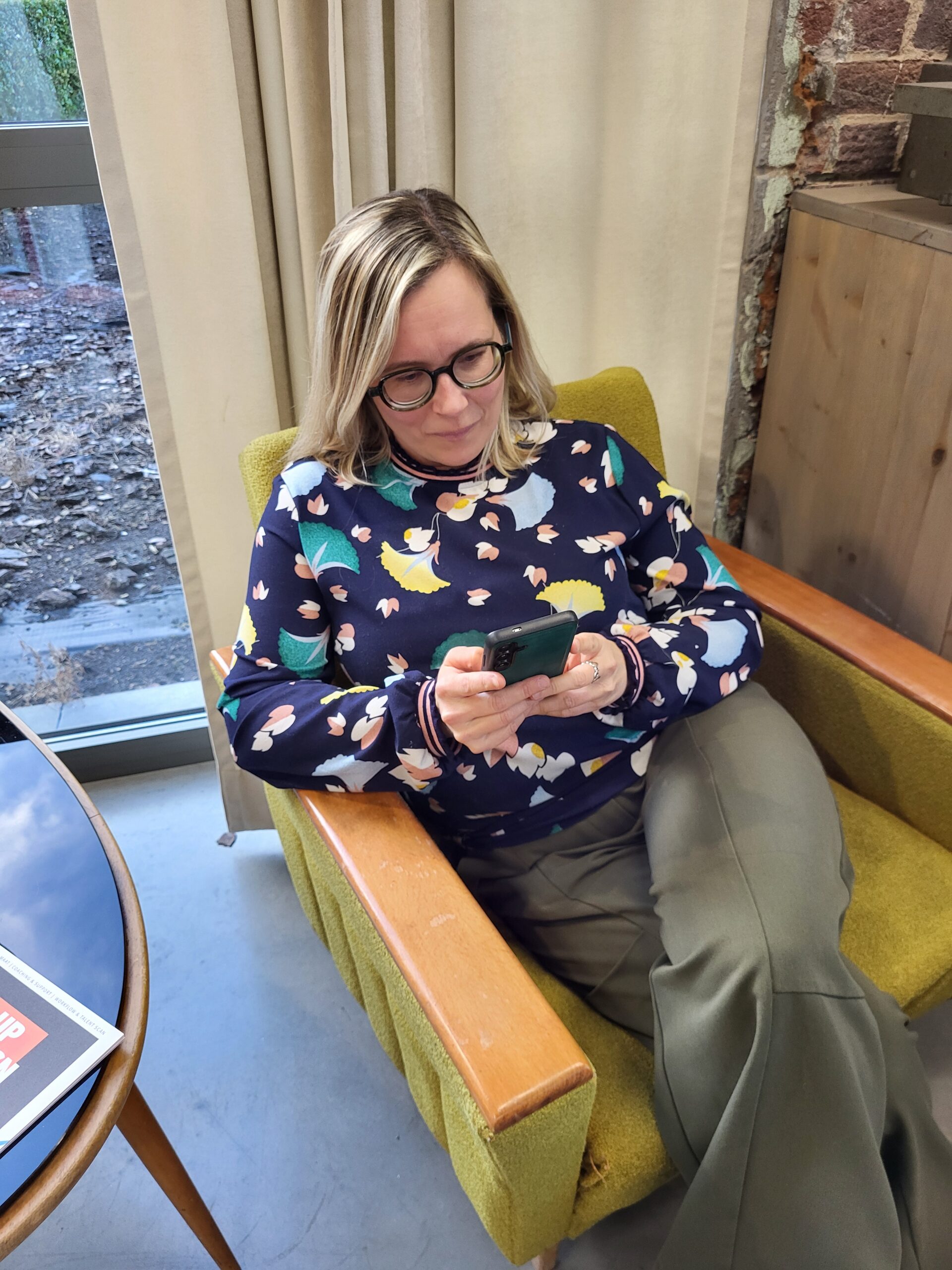 Copywriter Griet post op sociale media in een zetel.